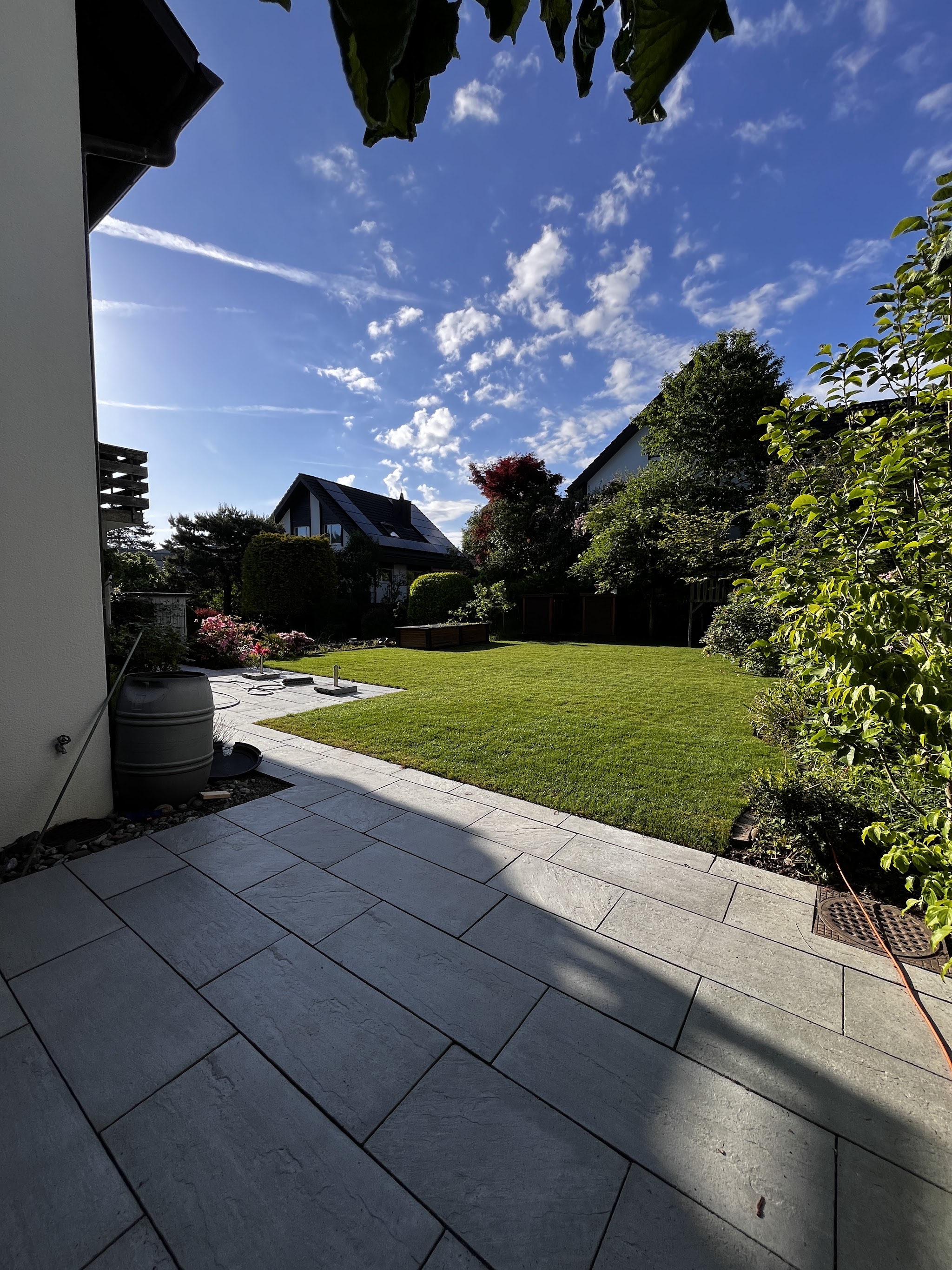 Gartenweg aus grauen Steinplatten entlang des Hauses